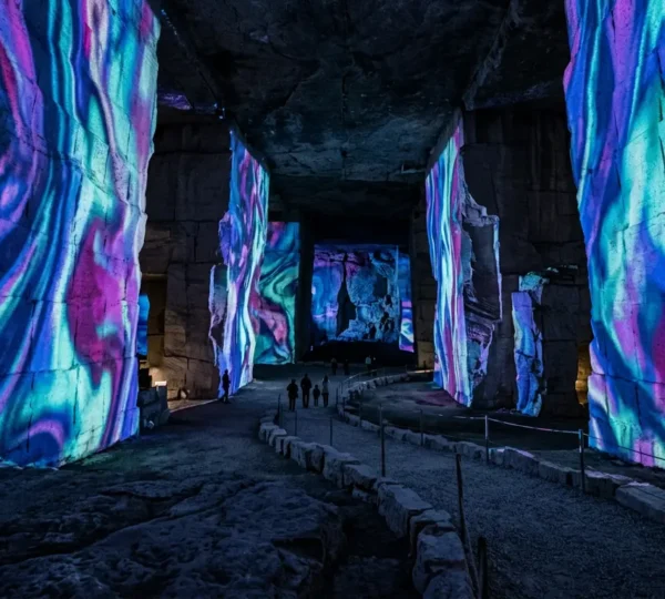 Vue intérieure spectaculaire des Carrières de Lumières avec projections colorées sur les parois calcaires monumentales