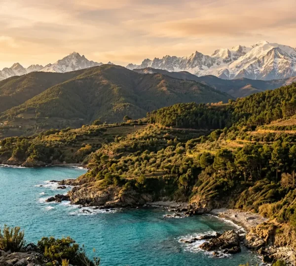 Vue panoramique montrant la transition spectaculaire entre la mer Méditerranée et les sommets enneigés des Alpes-Maritimes.